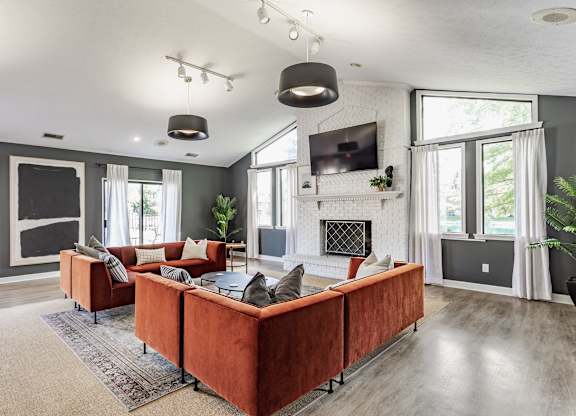 A modern living room with a red couch and a fireplace