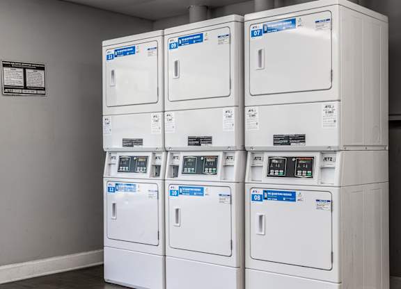 A stack of white electrical boxes with blue labels and meters.