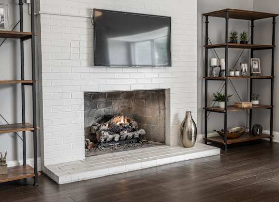 A modern living room with a fireplace and a flat screen TV mounted above it.