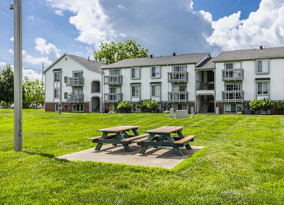 A picnic table is in front of apartment buildings.