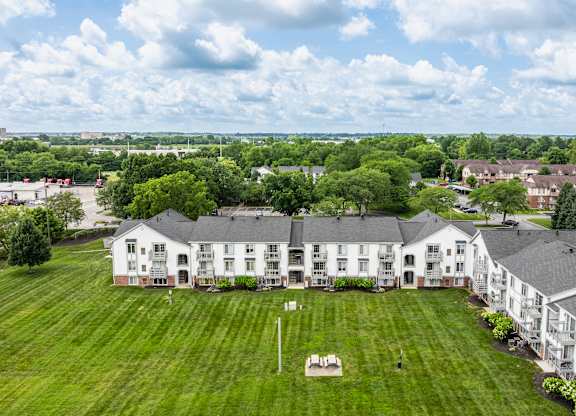 A large white building with a green lawn in front.