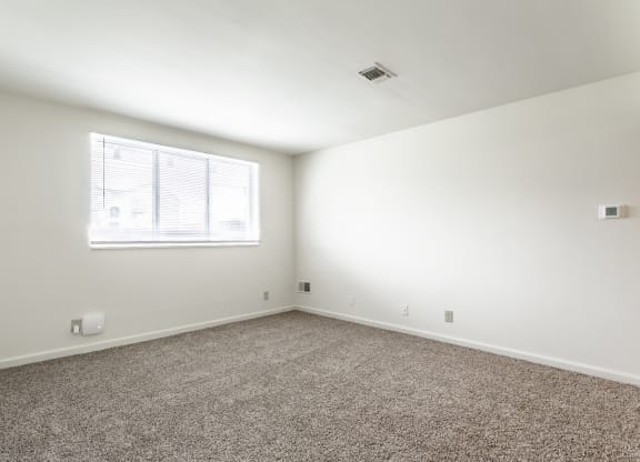 an empty room with carpet and a window at Bay Pointe Apartments in Lafayette, Indiana