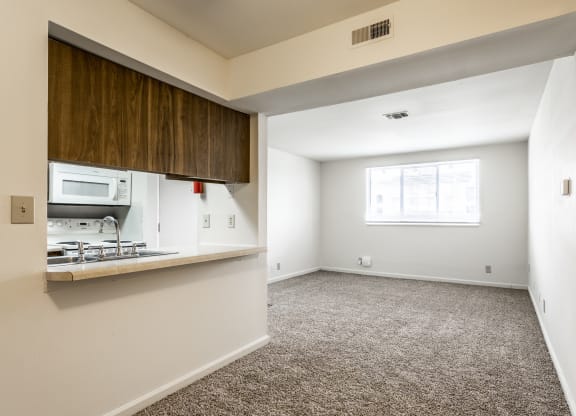 an empty living room with a kitchen and a window at Bay Pointe Apartments in Lafayette, Indiana 47909