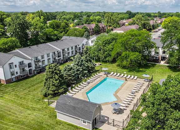 An aerial view of a resort with a swimming pool and lounge chairs.