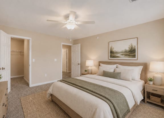 A bedroom with a large bed and a painting on the wall.