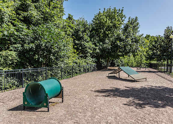 A playground with a green slide and a bench.