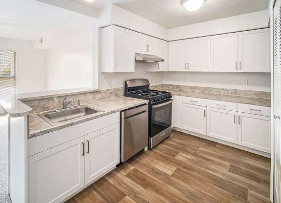 an upgraded kitchen with white cabinets and stainless steel appliances at Black Sand Apartment Homes in Lincoln, NE