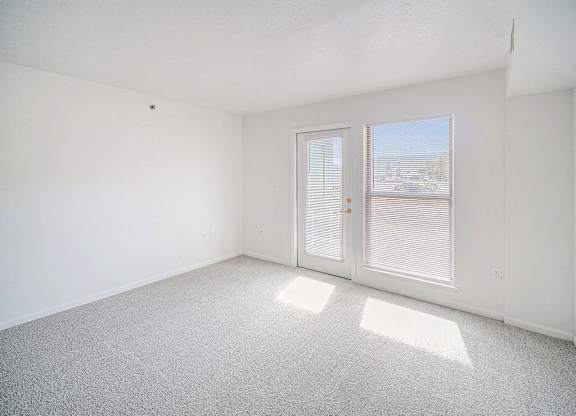 the living room with a door to a patio at Black Sand Apartment Homes in Lincoln, NE