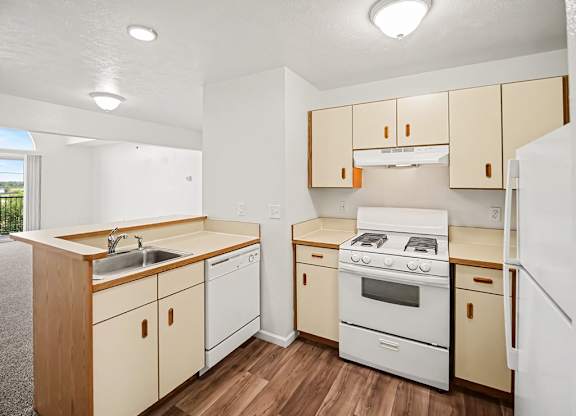 A kitchen with white appliances and wooden cabinets at Black Sand Apartments Homes, Lincoln, NE