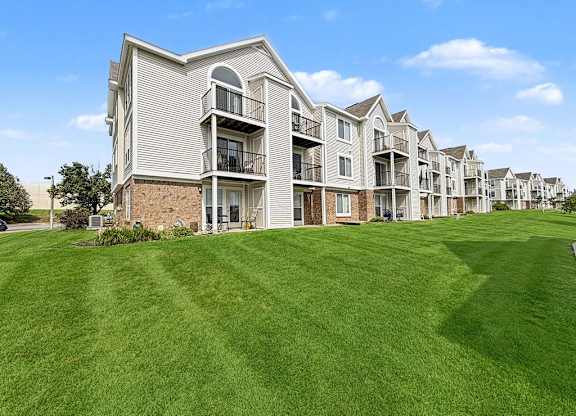 Multi story apartment buildings with green lawn at Black Sand Apartments Homes, Lincoln, NE 68504