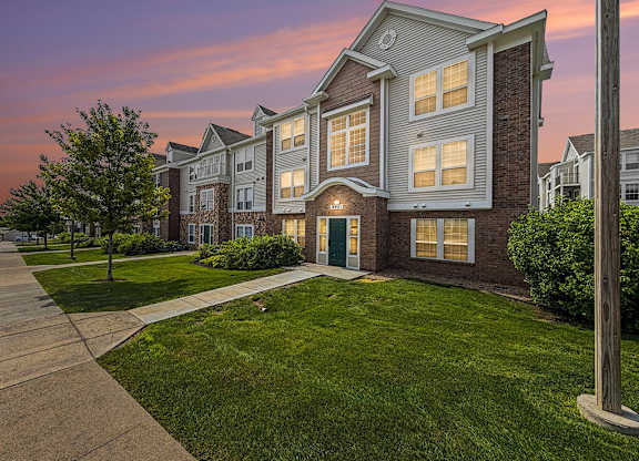 Three story apartment building at sunset with illuminated windows at Black Sand Apartments Homes, Nebraska, 68504