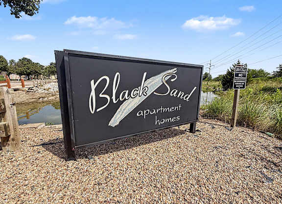 Property entrance sign with decorative wave design at Black Sand Apartments Homes, Lincoln