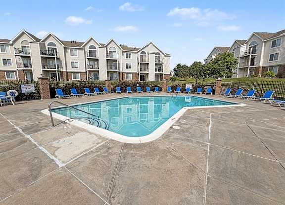 Community swimming pool with lounge chairs and apartment views at Black Sand Apartments Homes, Nebraska, 68504