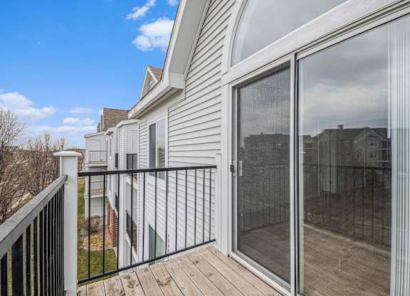 A balcony with enclosed storage and sliding glass doors at Brentwood Park Apartments in LaVista, NE