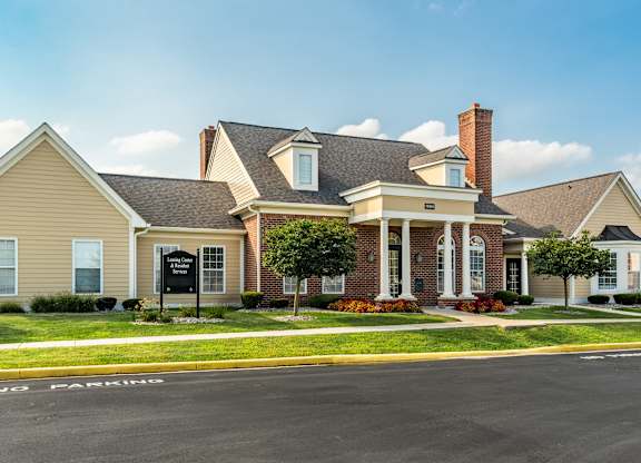 A large house with a brick chimney is situated on a street corner