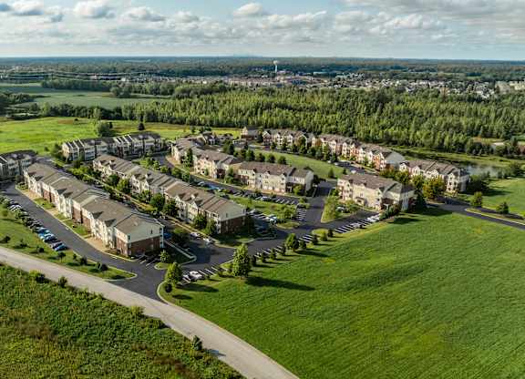 A large housing complex with a green lawn in front