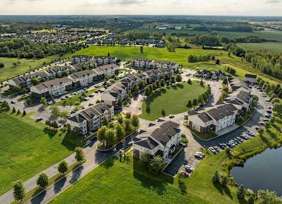 A bird's eye view of a housing complex with a lake in the foreground