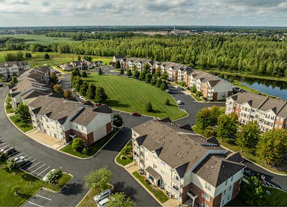 A bird's eye view of a residential complex with a lake in the background