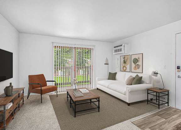 A living room with a white couch, a brown chair, and sliding glass doors to a balcony at Brookside Apartments, Springfield