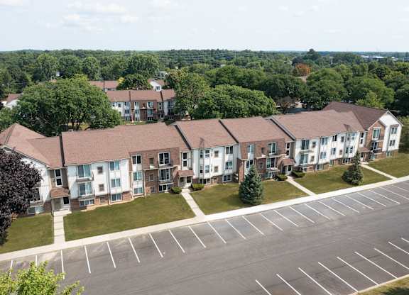 A large apartment complex with a parking lot in front.