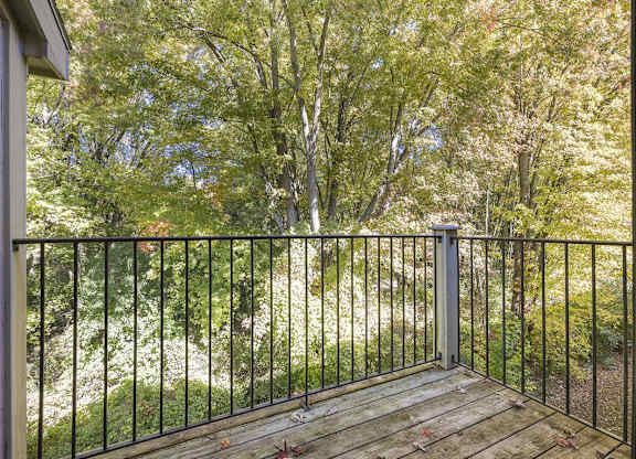 a balcony with a view of trees at Byron Lakes Apartments, Michigan