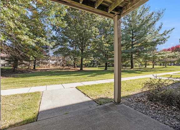 a private patio overlooking park like grounds with trees  at Byron Lakes Apartments, Byron Center, MI, 49315