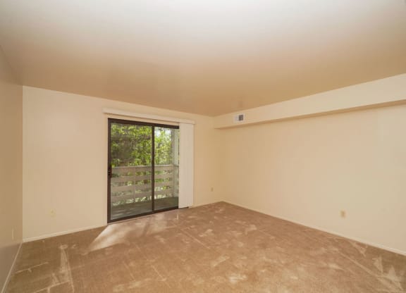 Living Room Leads to Balcony at Canal Club Apartments in Lansing, MI