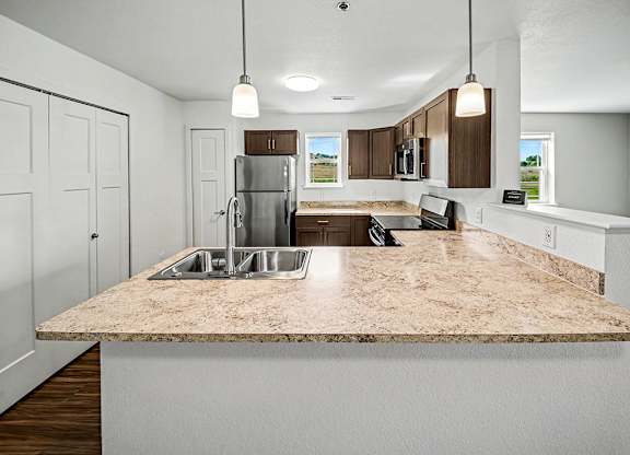 A kitchen with a granite countertop and white cabinets.