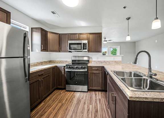 A kitchen with wooden floors and stainless steel appliances.