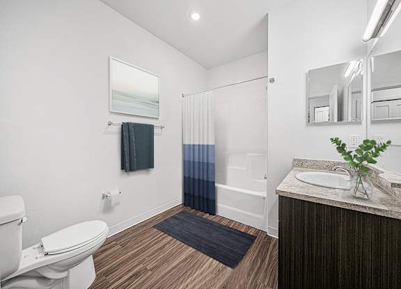 A bathroom with a toilet, sink, and mirror at Chase Creek Apartment Homes, Huntsville, AL, 35811