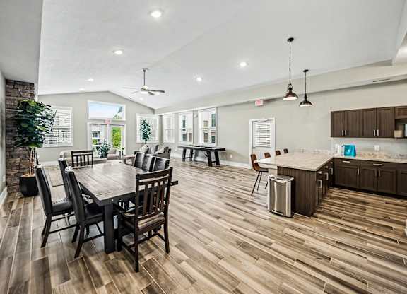 A modern clubhouse kitchen and dining area with hard-surface flooring and abundant windows at Chase Creek Apartment Homes, Huntsville, AL, 35811