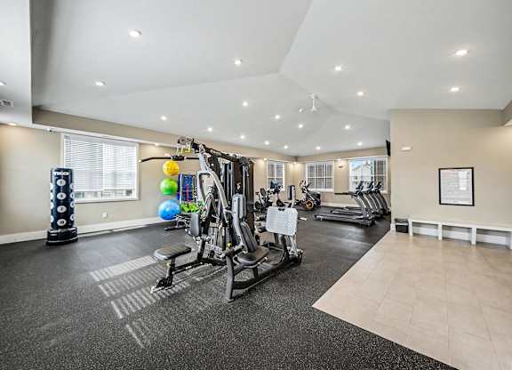 A spacious gym with a variety of equipment including treadmills, weights, and exercise balls at Chase Creek Apartment Homes, Huntsville, AL, 35811