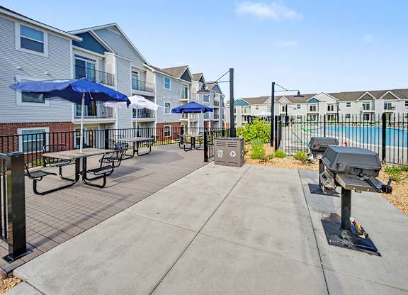 A sunny day at the outdoor grilling area with seating at Chase Creek Apartment Homes, Huntsville, AL, 35811