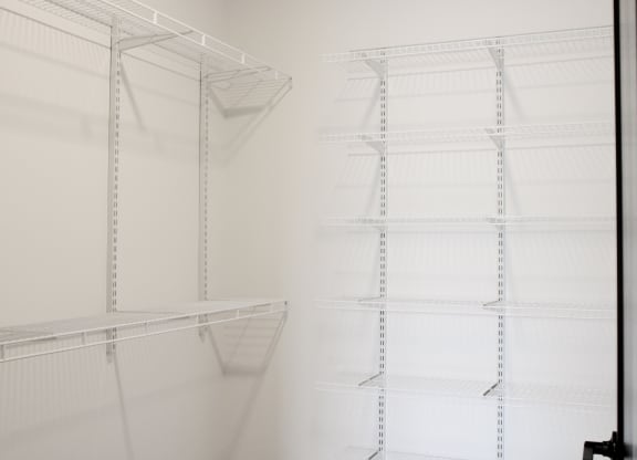 a walk in closet with white shelving and white walls  at Avant & Avant II, Carmel, 46032