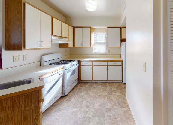 end style kitchen with window and white appliances at Canal Club Apartments, Lansing, Michigan