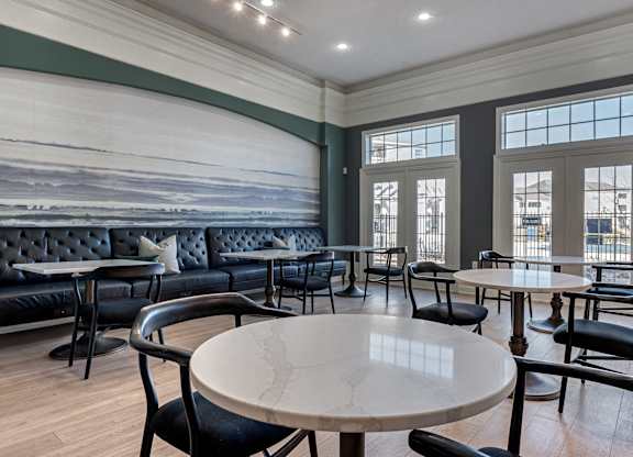 a dining room lounge with tables and chairs and a wall mural at Latitudes Apartments, Indiana