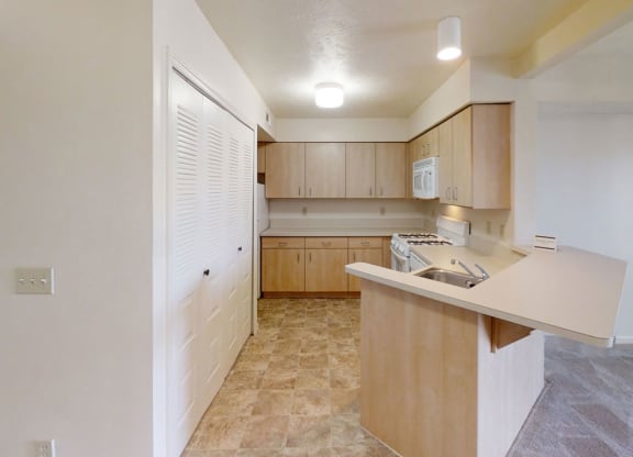 a kitchen with wooden cabinets and white appliances at Colonial Pointe at Fairview Apartments, Bellevue, NE
