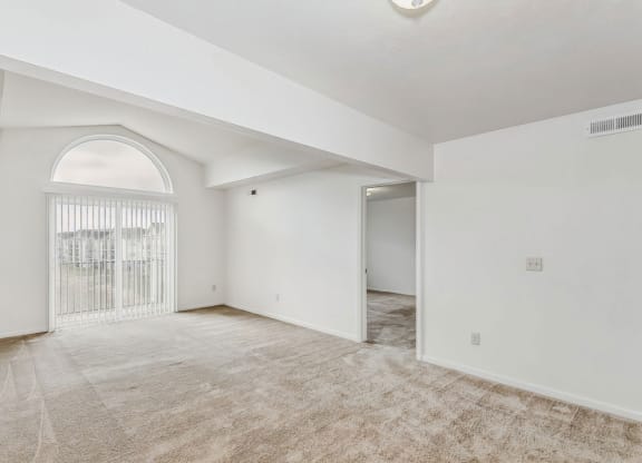 the living room and dining room with a large arched window at Colonial Pointe at Fairview Apartments, Nebraska