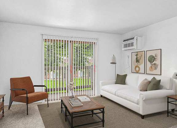 A living room with a white couch and a slider to a balcony at Concord Place Apartments in Kalamazoo, Michigan 49009