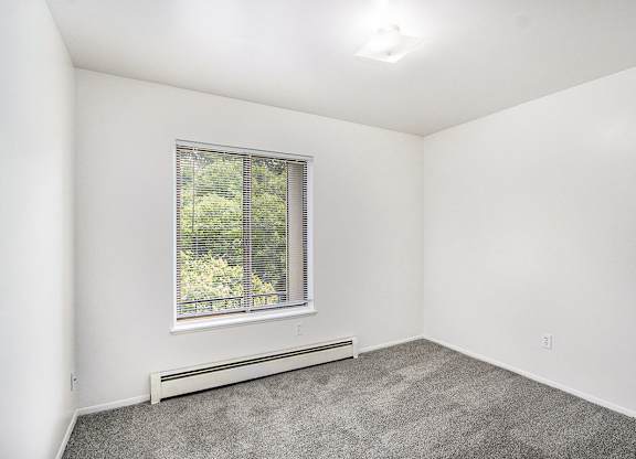 A bedroom with a large window at Concord Place Apartments, Kalamazoo, MI