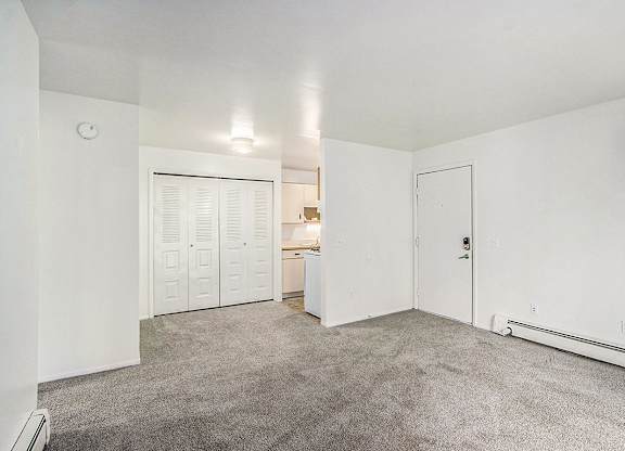 A large living and dining room with a carpeted floor at Concord Place Apartments, Kalamazoo, MI