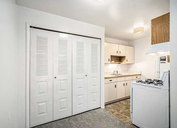 A kitchen with white appliances and wooden cabinets at Concord Place Apartments, Kalamazoo, MI