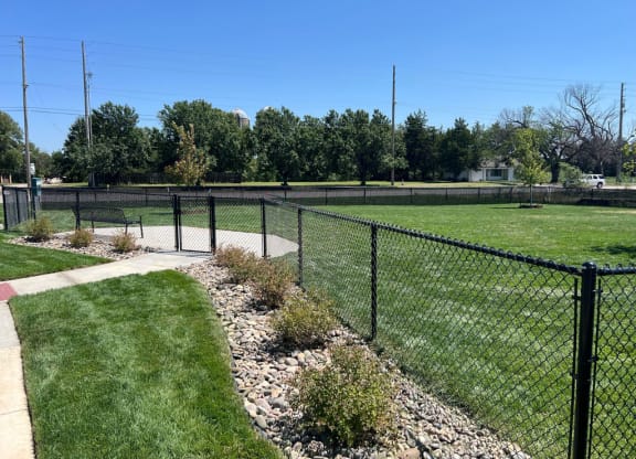 a dog park with a bench and fence at Copper Creek Apartments in Maize, KS