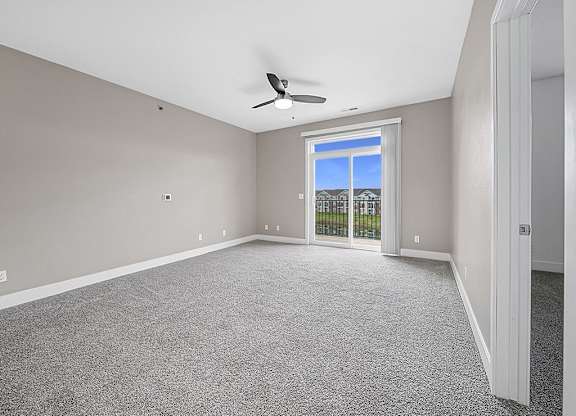 A living room with a 9' ceiling and a ceiling fan an empty bedroom with a ceiling fan and ensuite at Copper Creek Apartment Homes, Kansas, 67101
