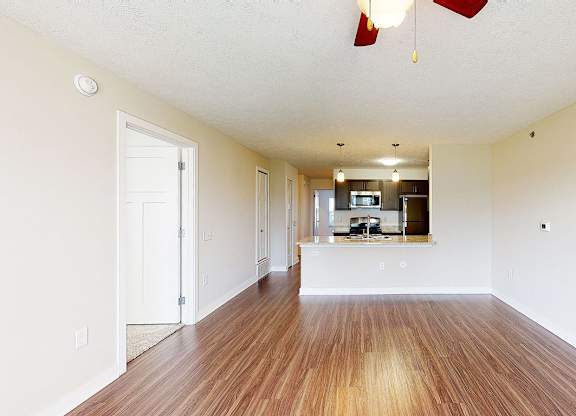A long, empty living room with hard-surface floors  at Copper Creek Apartment Homes, Maize, Kansas