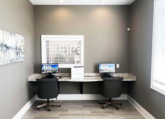 Dual workspace with monitors and office chairs at Copper Creek Homes Apartments, Kansas