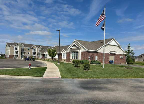 Community entrance with flags and landscaping at Copper Creek Homes Apartments, Kansas, 67101