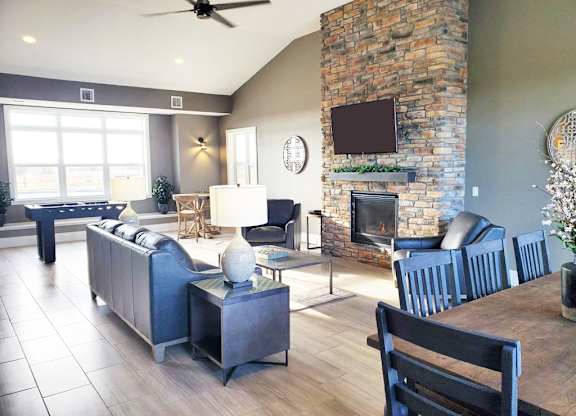 Open concept living and dining room with stone fireplace at Copper Creek Homes Apartments, Maize, KS 67101