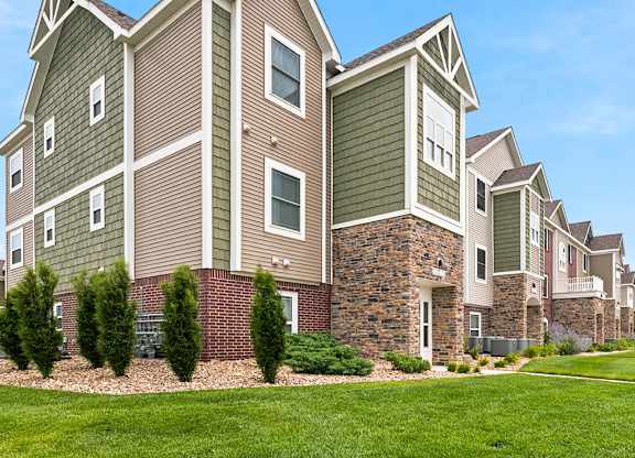 Residential building exterior with stone and siding accents at Copper Creek Homes Apartments, Maize