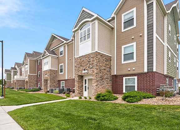 Multi level apartment building with brick and stone accents at Copper Creek Homes Apartments, Kansas